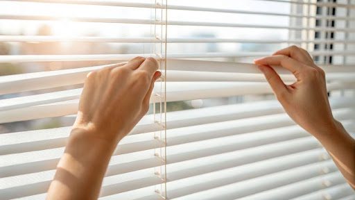 a person fixing blinds